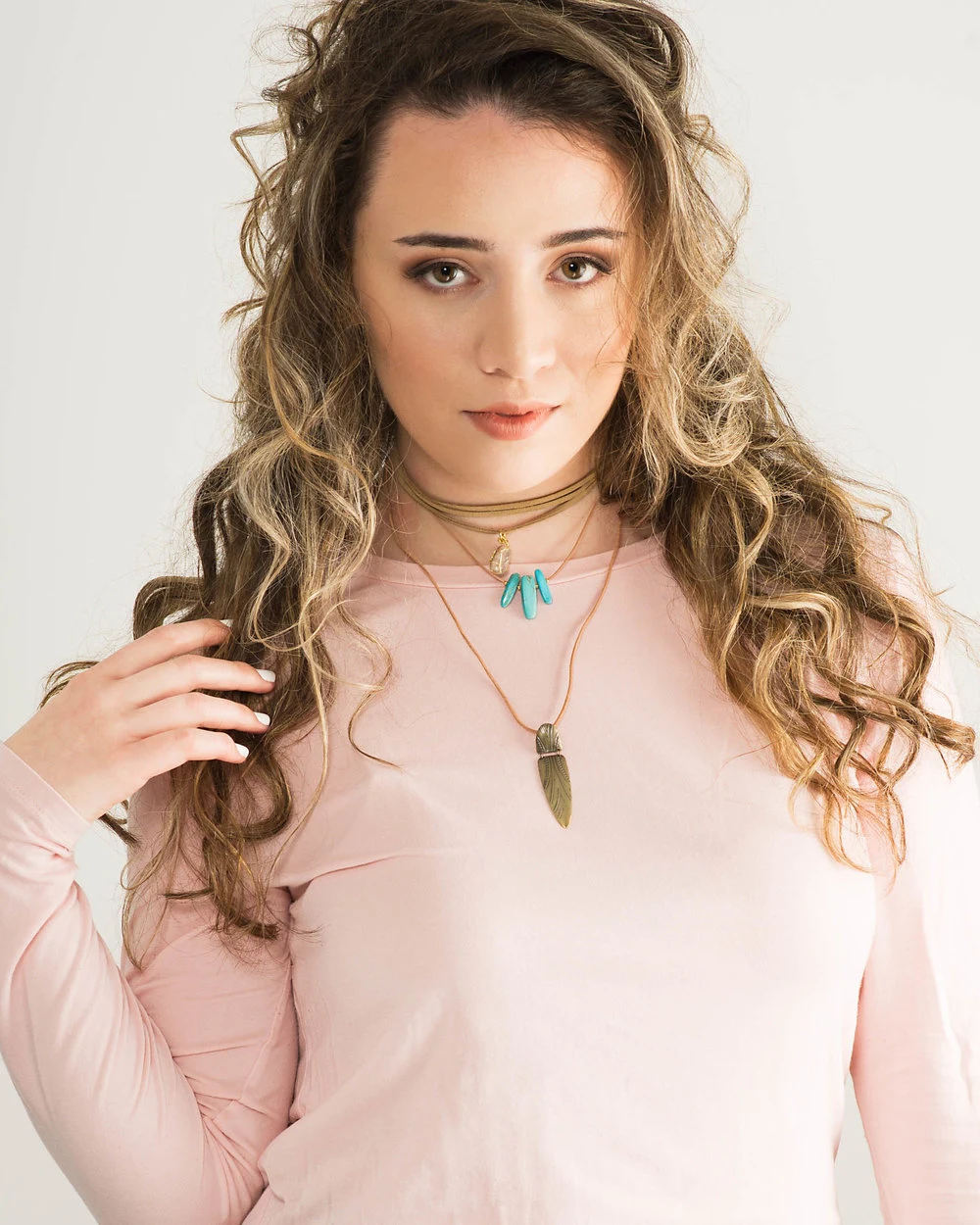 Portrait in a pale pink top against a light backdrop