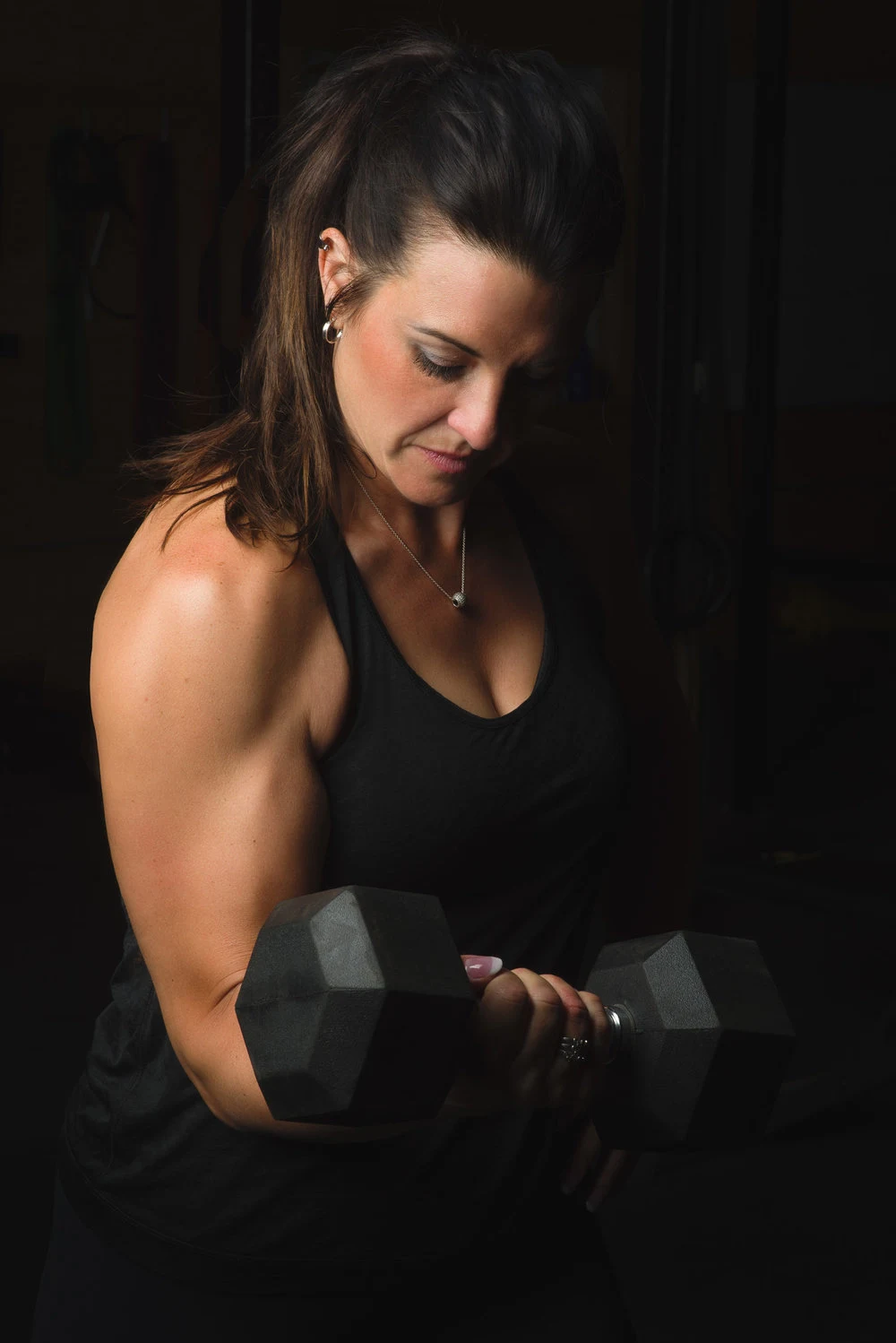 Athletic portrait of a woman holding a weight