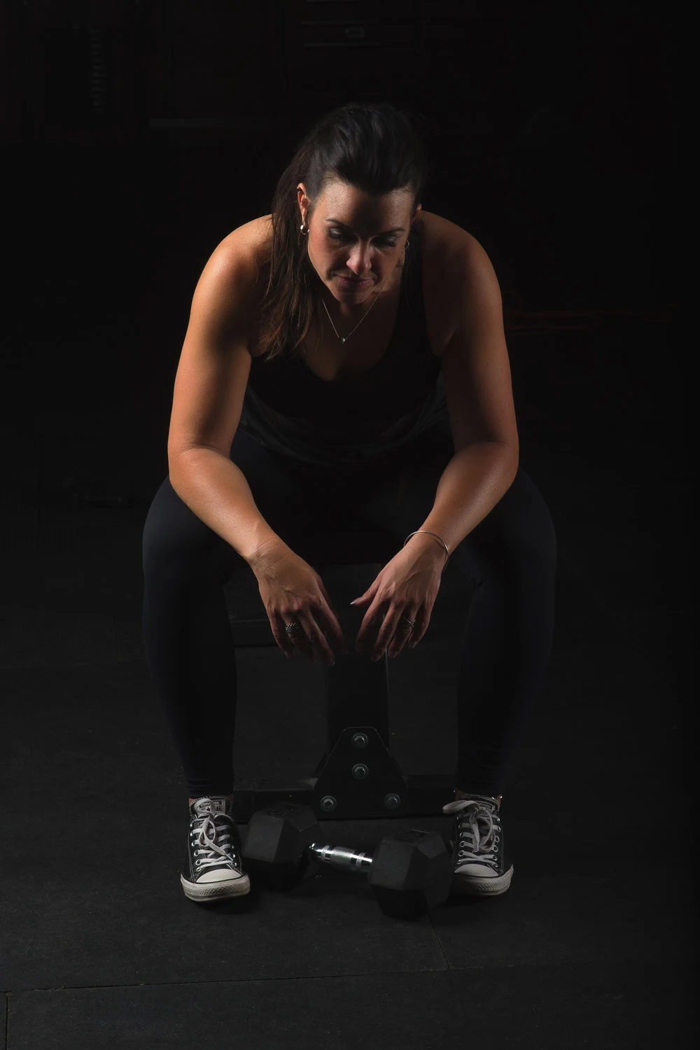 Seated athletic portrait against a dark backdrop