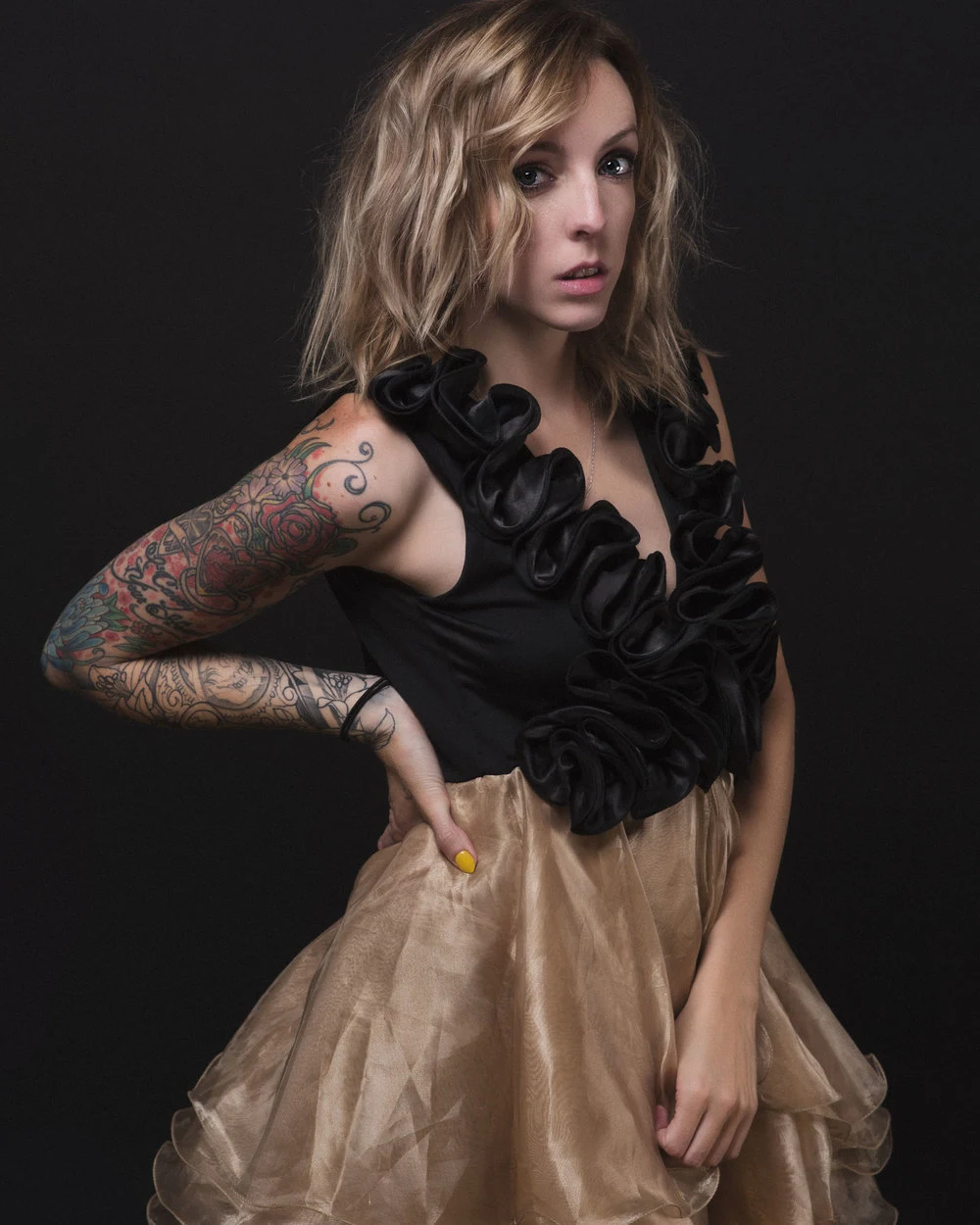 Editorial portrait in a black lace top and gold skirt
