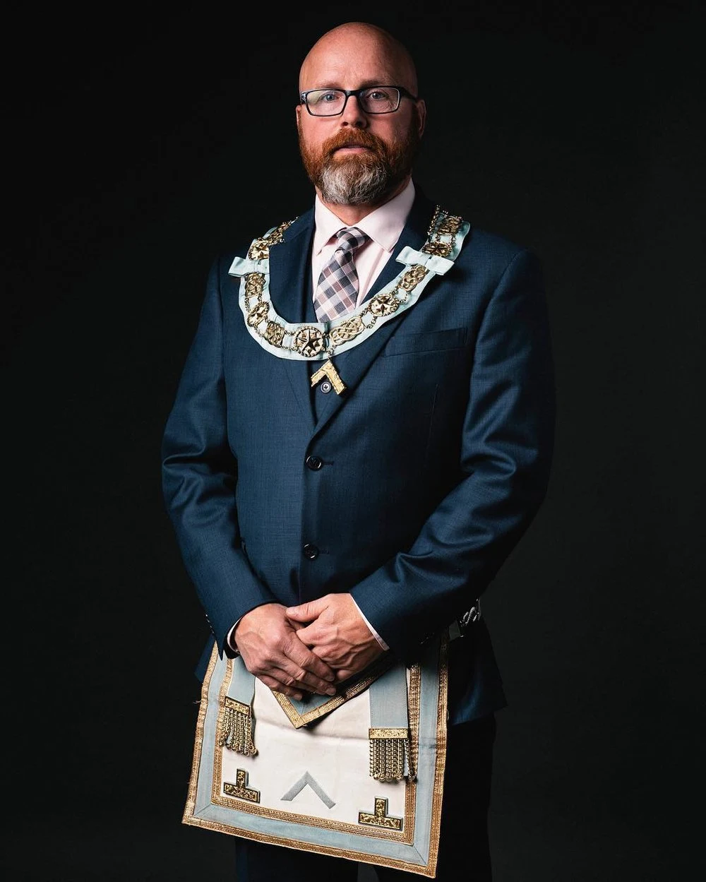 Formal portrait in a blue suit and ceremonial regalia
