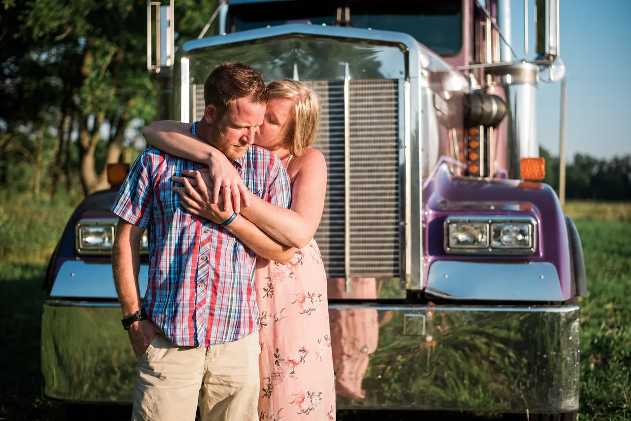 Couple embracing beside a vintage vehicle