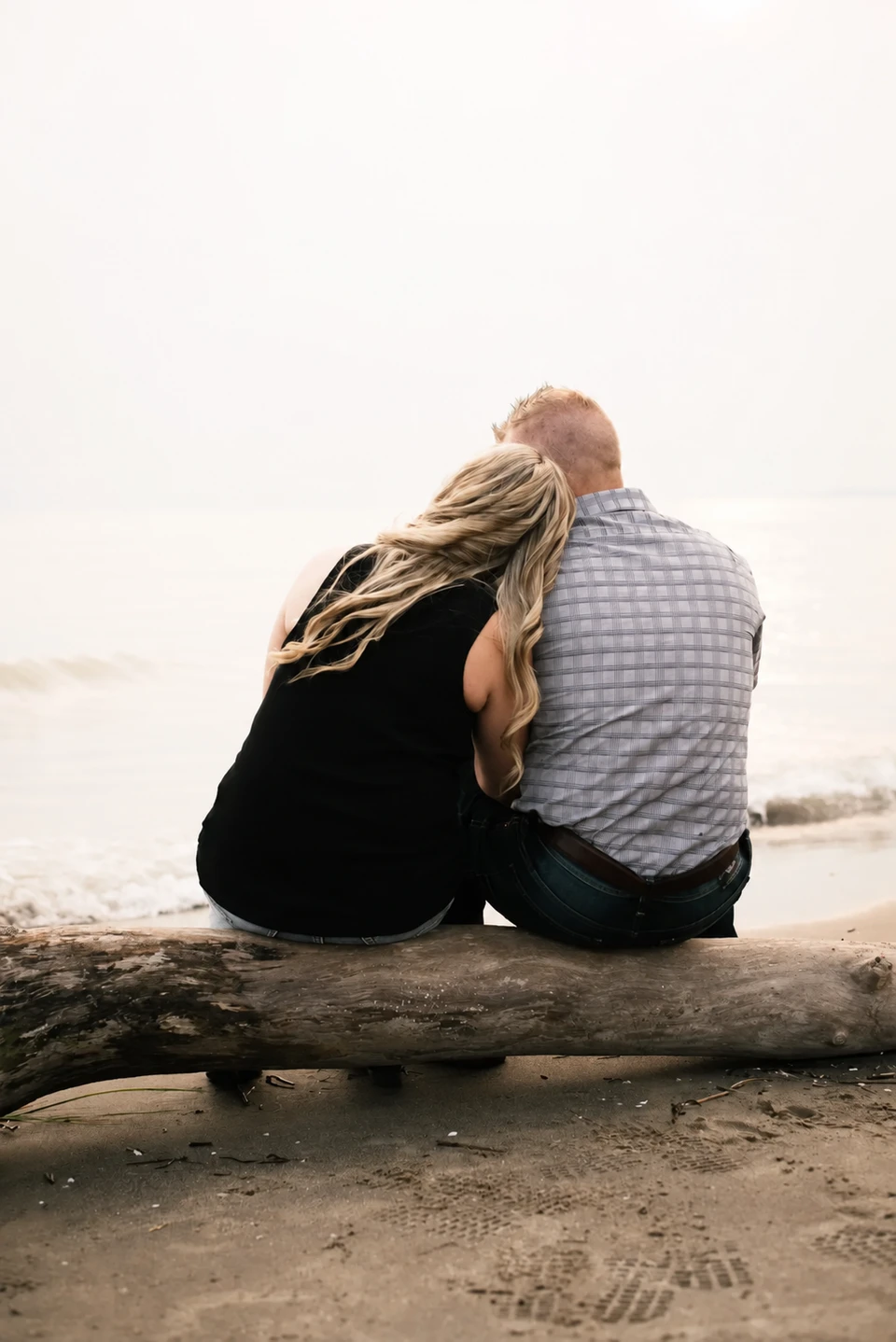 Couple sitting together on rocks beside the water