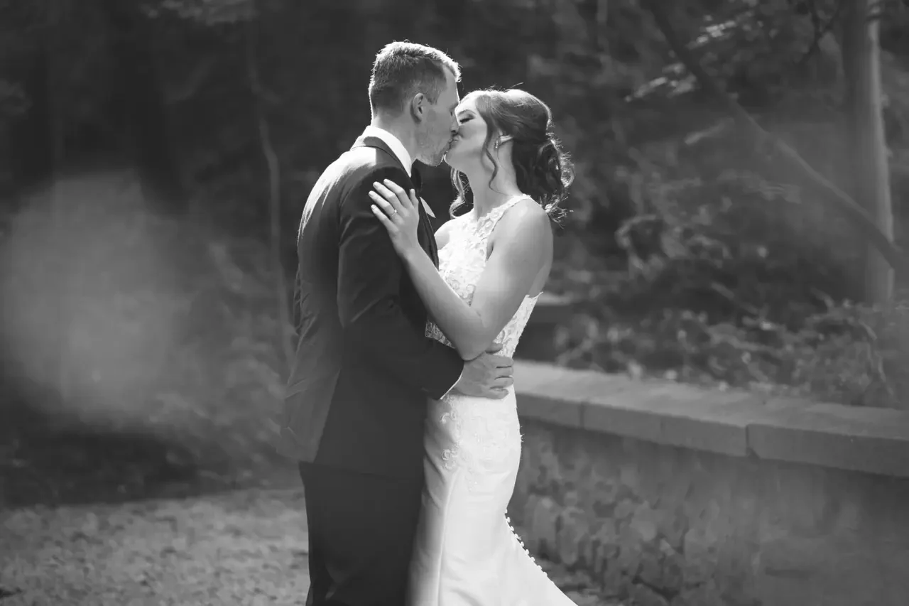 Black and white wedding portrait of a couple kissing