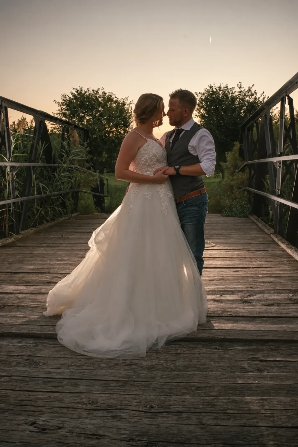 Wedding couple embracing on a bridge