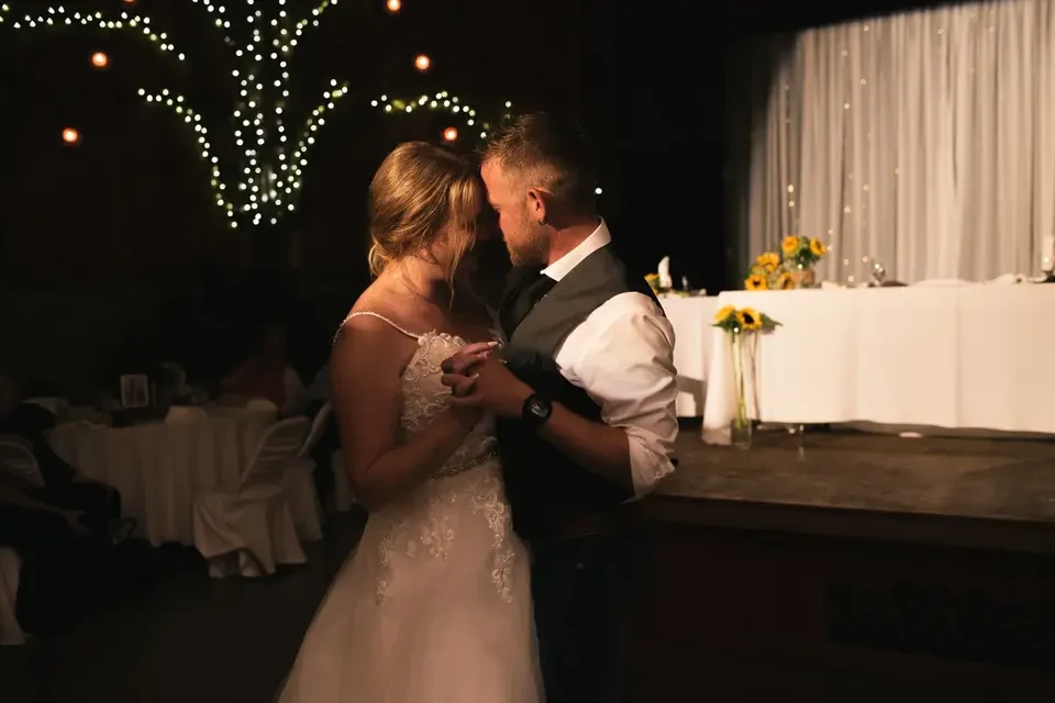 Wedding couple dancing under warm lights