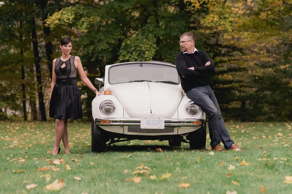 Couple posing beside a vintage car