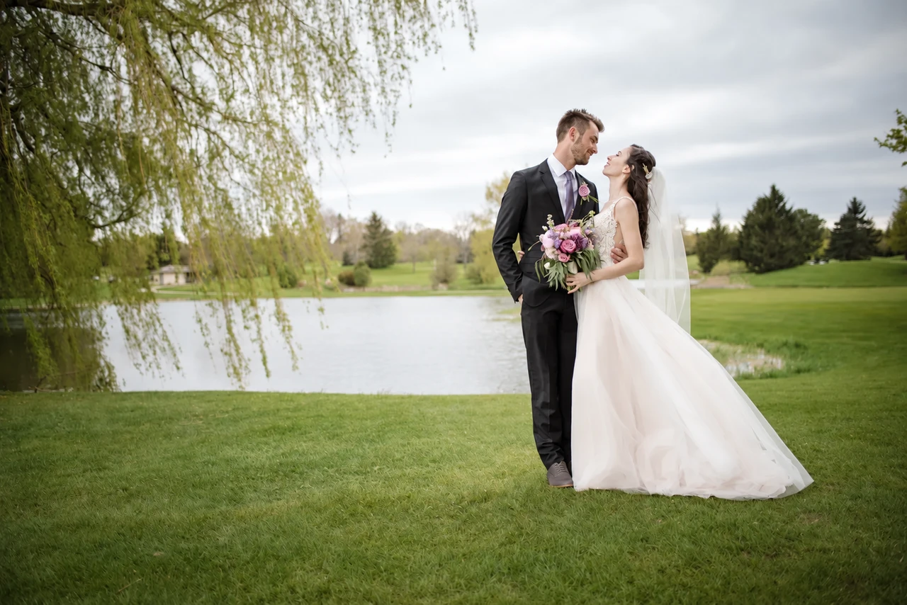 Wedding couple beside a willow tree and pond