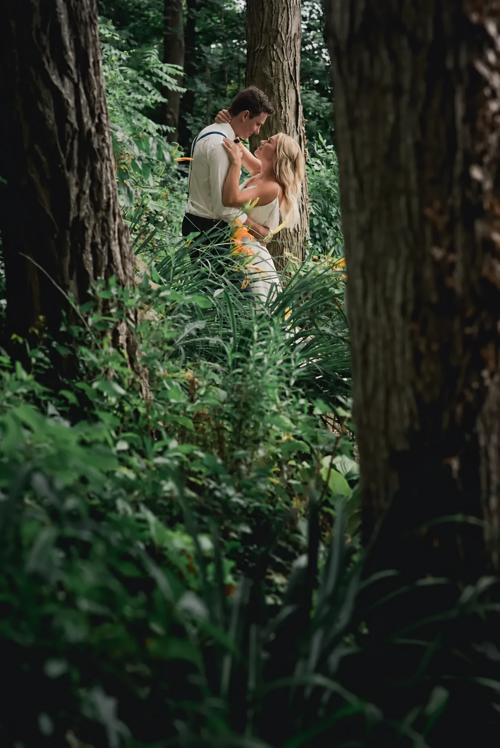 Wedding portrait among tall green trees
