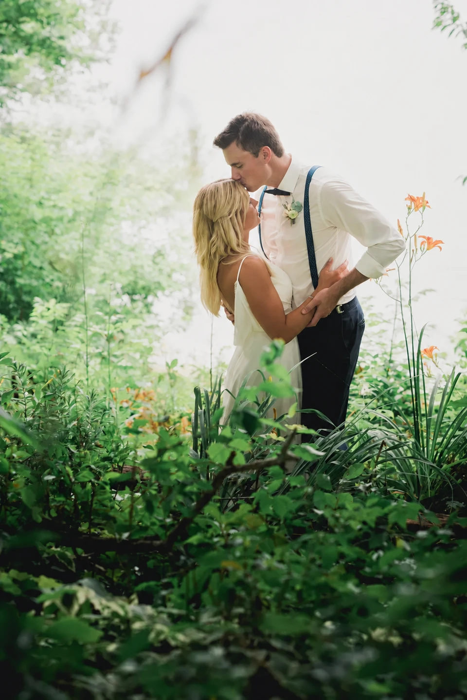 Wedding couple embracing in woodland